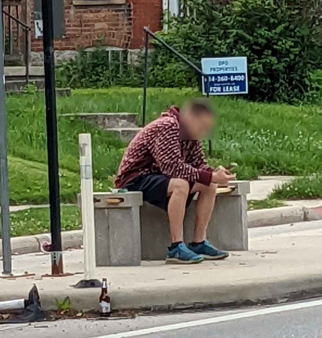 A picture of someone sitting on the first improvised bench